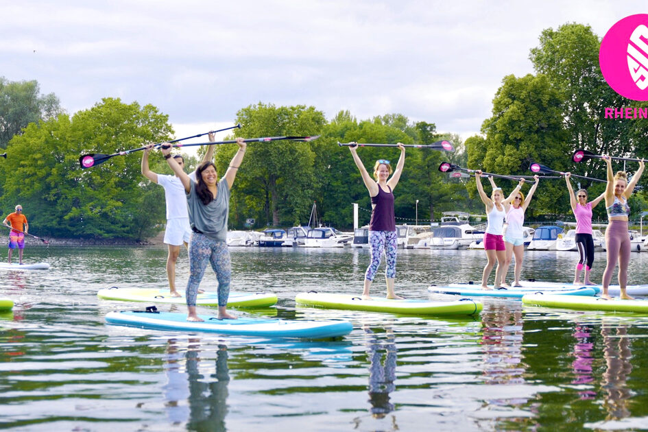 Teilehmer halten ihre Paddel hoch