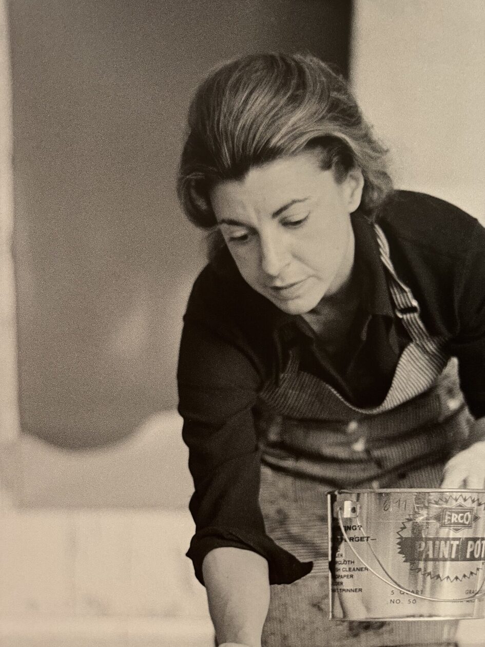 Femme qui peint avec un pot de peinture.