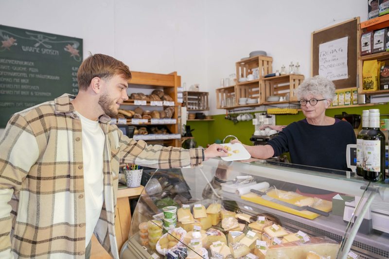 Ein Mann probiert Käse in einem Laden