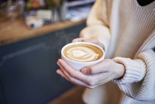 Kaffeetasse in der Hand einer jungen Frau