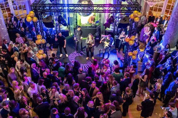 Menschen stehen vor einer Bühne mit einer Band