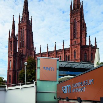 Logo am Eingang des sam vor dem Hintergrund der Marktkirche