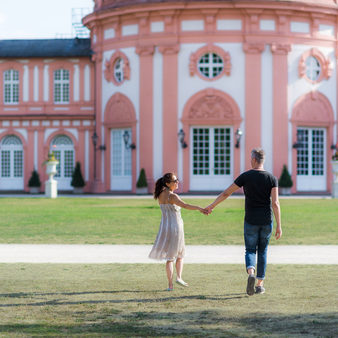 Pärchen schlendert durch Park auf das Biebricher Schloss zu