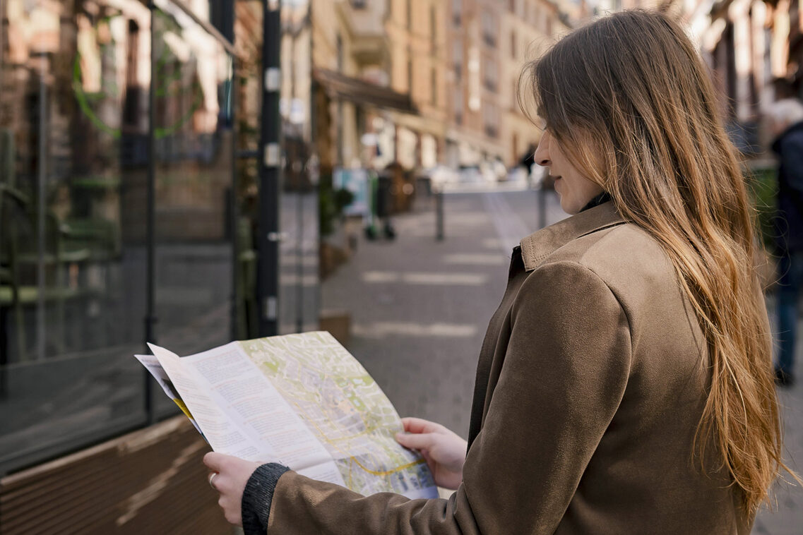 Frau schaut in Karte. Stadtführung