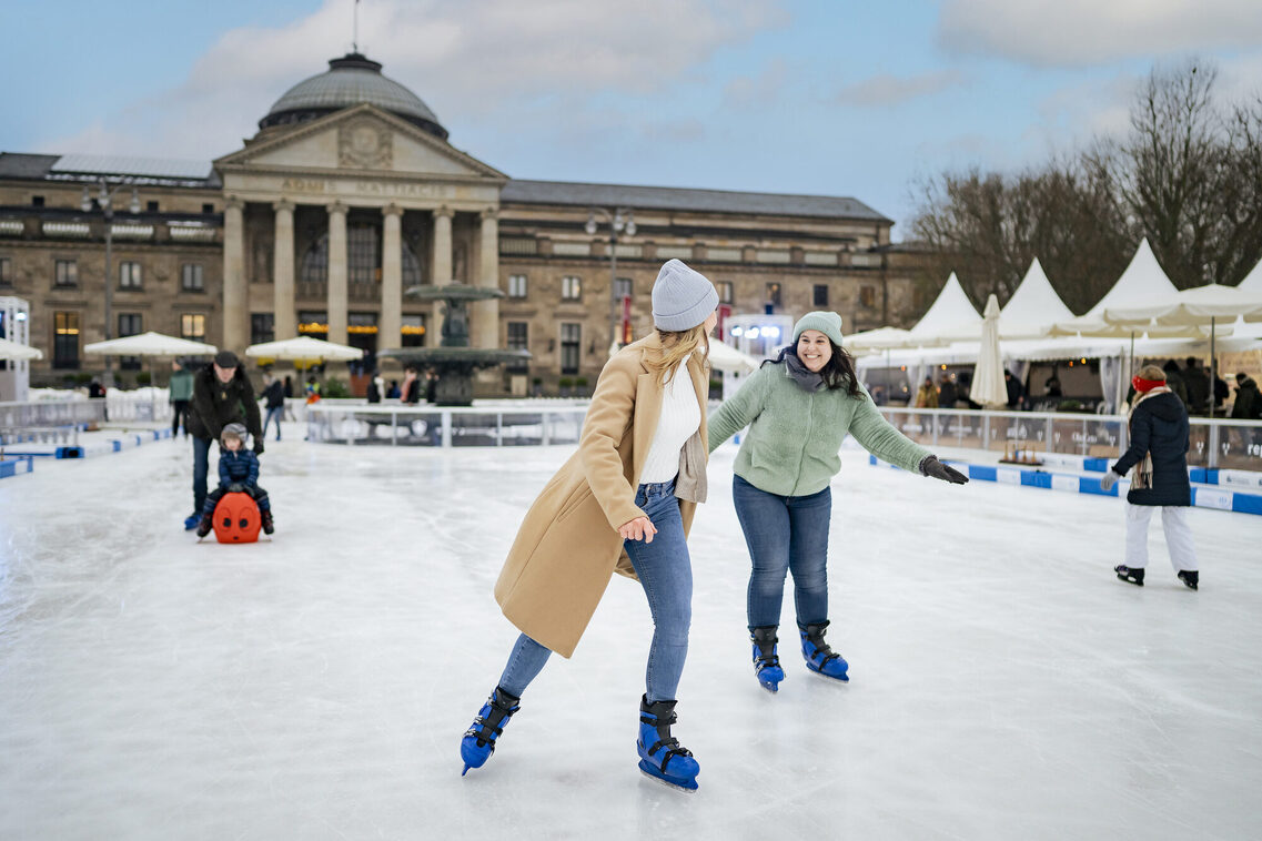Kurhaus, Eisbahn, zwei Frauen laufen Eis.
