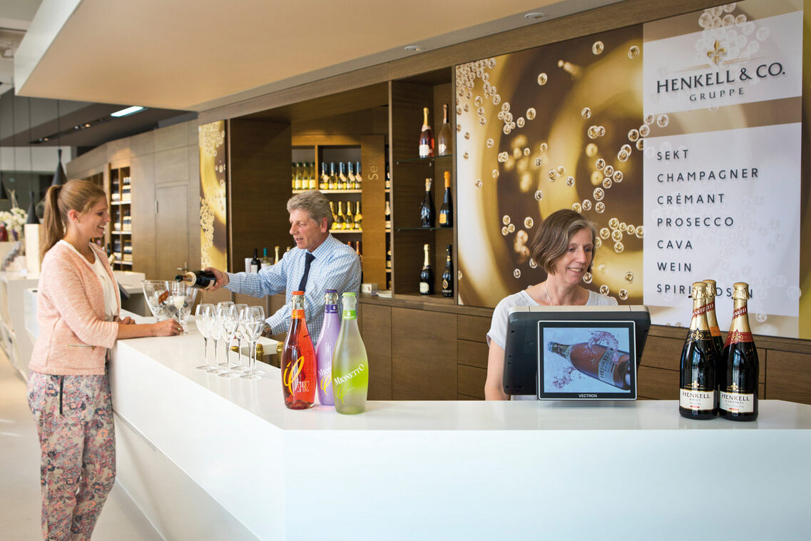 Store employee pours champagne at the counter