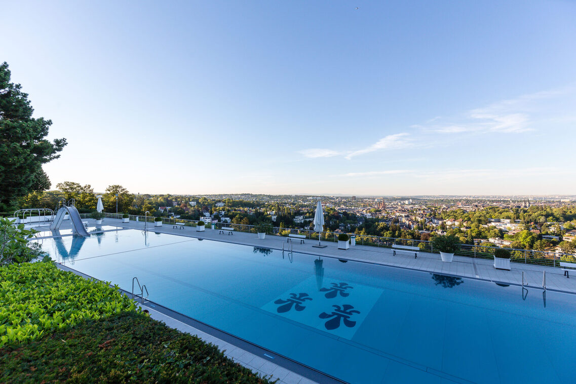 Wiesbaden Opelbad, swimming pool with the Wiesbaden logo on the bottom and a view over Wiesbaden.
