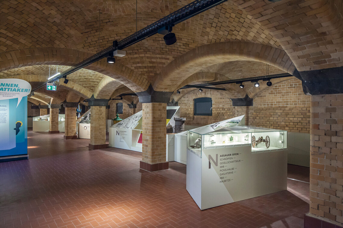 in the vaulted cellar, brightly lit display cases