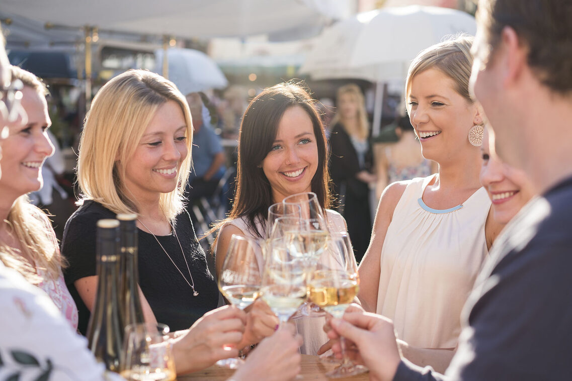 I giovani stringono i bicchieri di vino