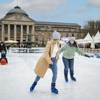 Kurhaus, Eisbahn, zwei Frauen laufen Eis.