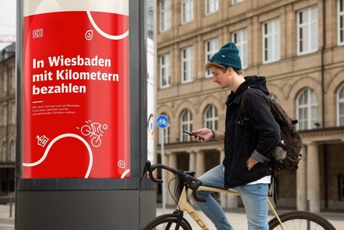 Radfahrer vor Werbesäule der Deutschen Bahn