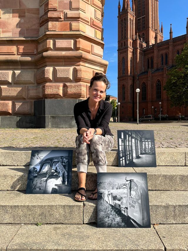 Junge Frau mit Fotos auf Treppenstufen