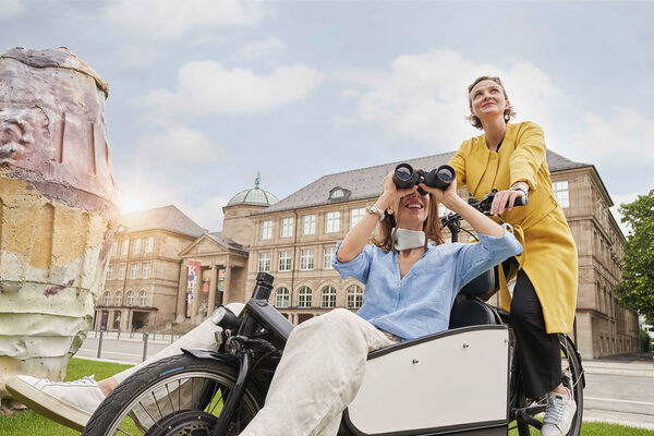 Frauen auf Lastenrad vor historischem Gebäude