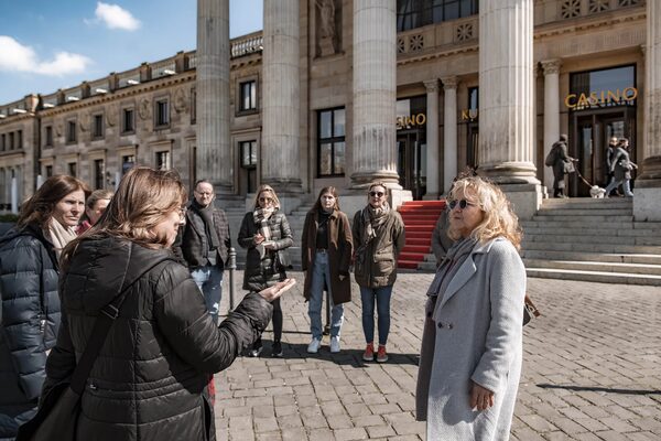 Frauen und Männer vor historischem Gebäude.