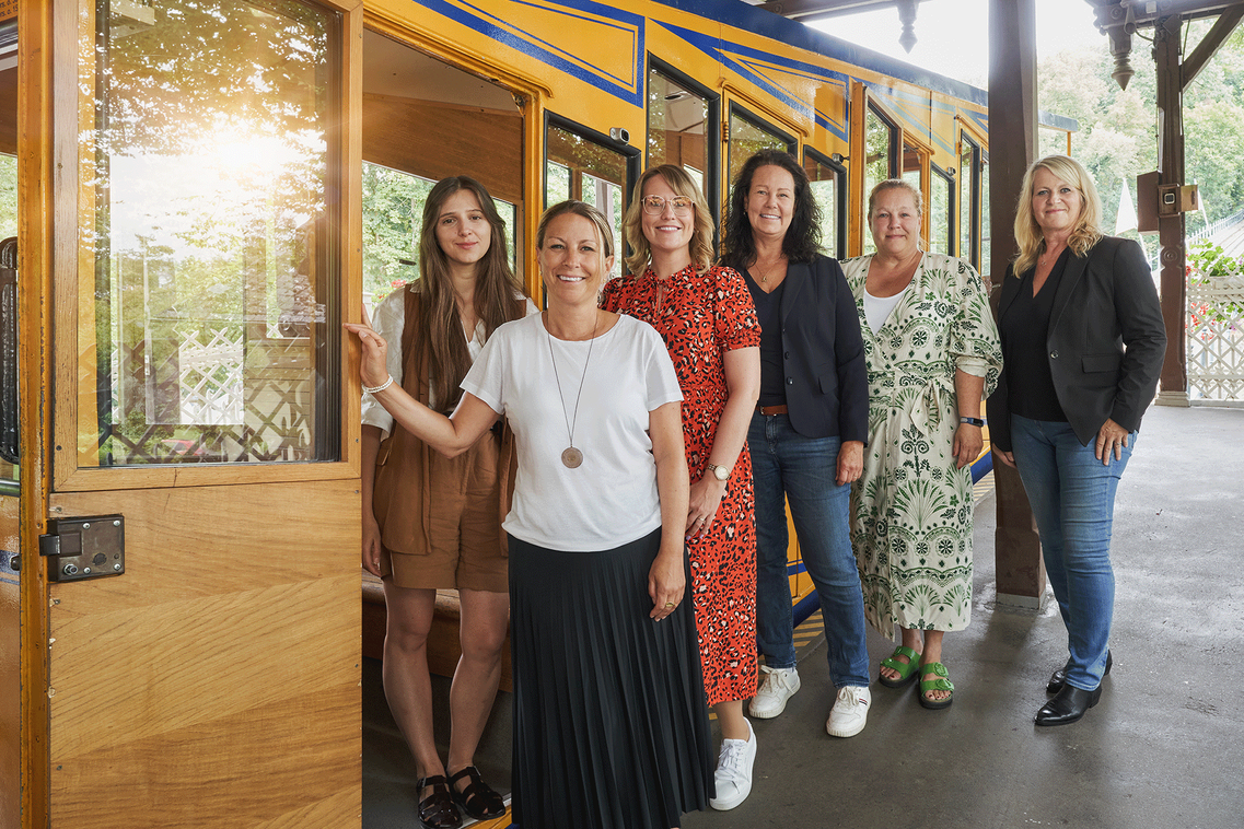 Fünf sechs Frauen vor einer historischen Bahn - Gruppenbild.