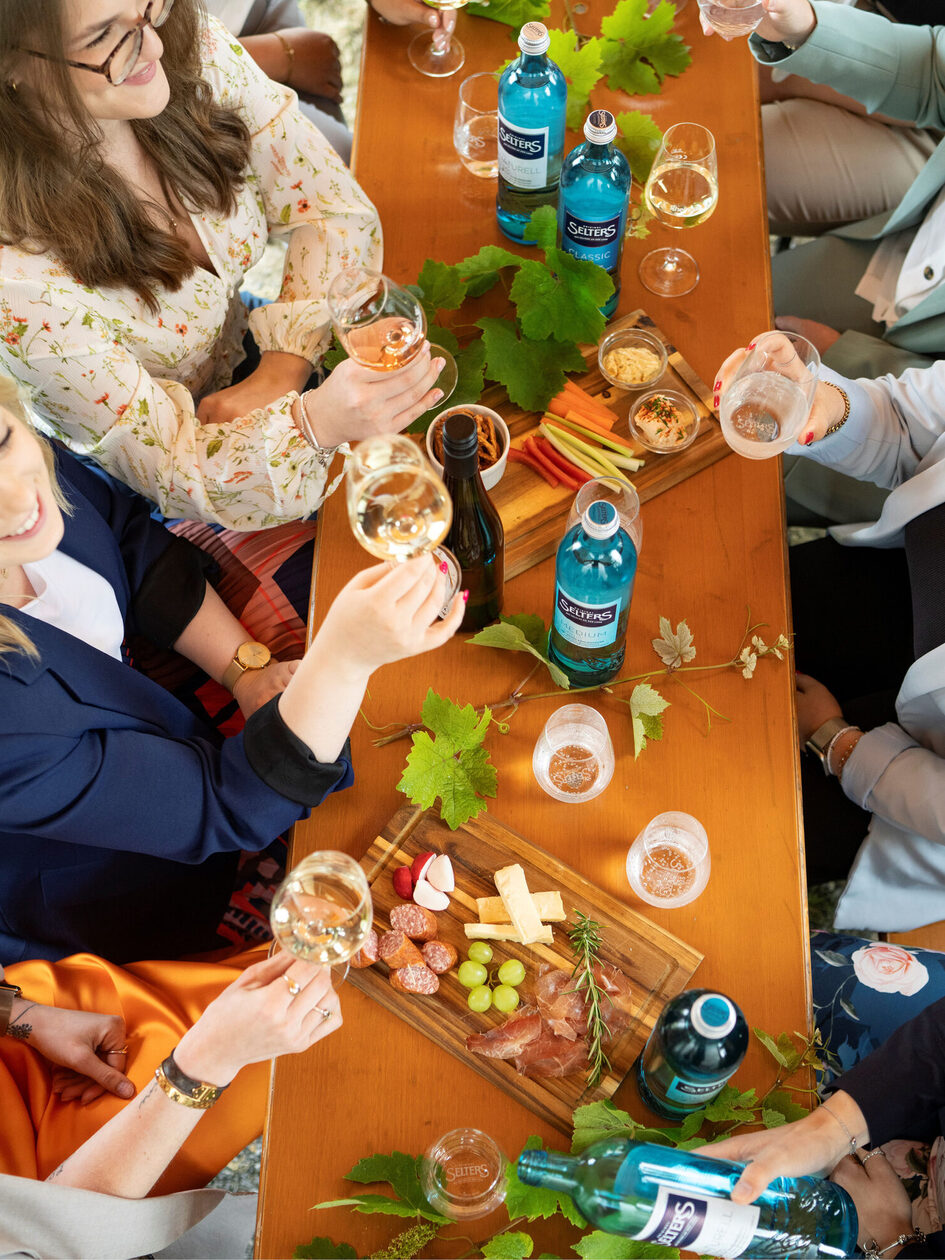 Tisch mit verschiedenen Wurst- und Käseplatten und Wein