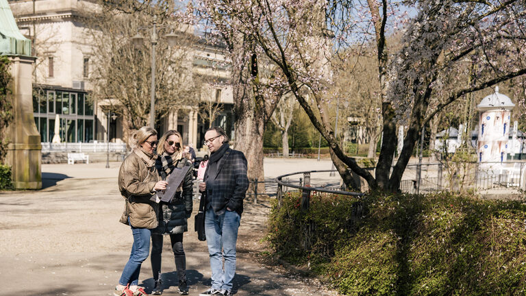 Мужчина и две женщины в садах курорта.